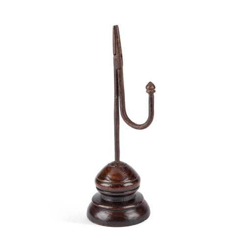 1 - AN 18TH CENTURY IRON RUSH LIGHT with a wooden base. 28cm high