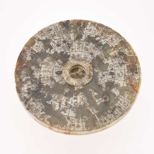 1013 - A CHINESE STONE FENG SHUI DIAL in two sections.14cm high, 24cm diameter