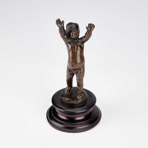 1069 - A 19TH CENTURY FRENCH SCHOOL BRONZE OF A CHERUB on a wooden socle. 20cm high overall... 