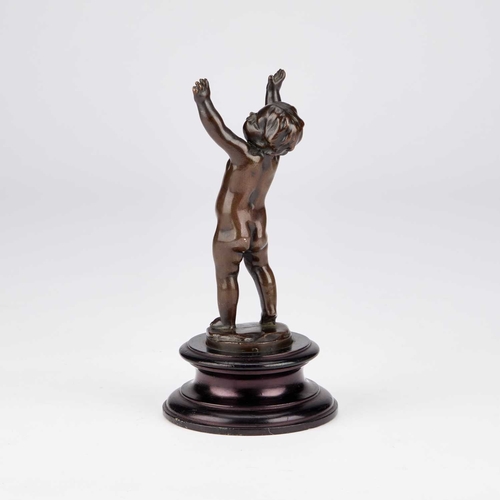 1069 - A 19TH CENTURY FRENCH SCHOOL BRONZE OF A CHERUB on a wooden socle. 20cm high overall... 