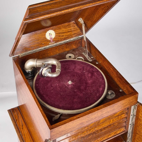 1310 - AN EARLY 20TH CENTURY OAK CASED ROBEY GRAMOPHONE the oak case with a hinged cover above a pair of do... 