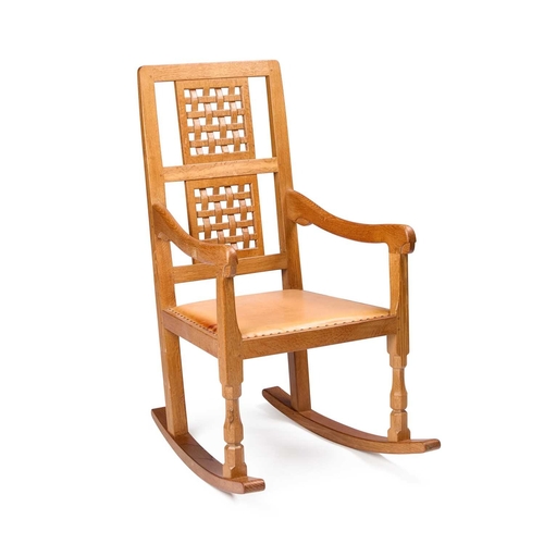 1360 - ROBERT THOMPSON OF KILBURN, A MOUSEMAN OAK ROCKING CHAIR with a double-panel lattice back, raised on... 