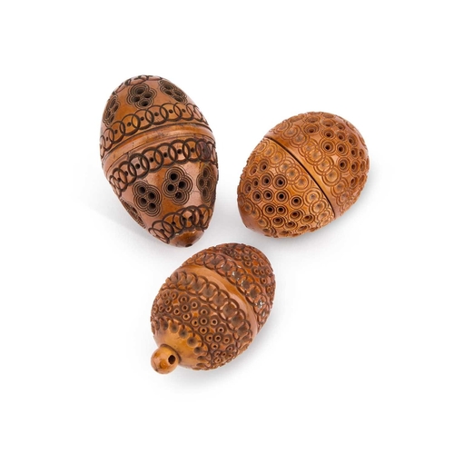 170 - THREE CARVED COQUILLA NUTS including a sewing box, each egg-shaped. (3) Largest 7.5cm high