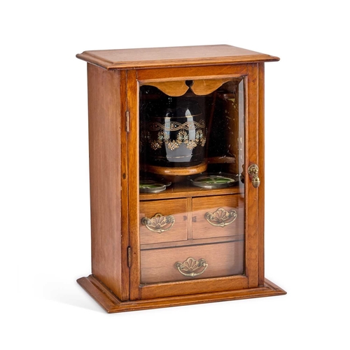 233 - AN EDWARDIAN OAK SMOKERS CABINET the interior with a tobacco jar and pair of ashtrays. 39.5cm high... 