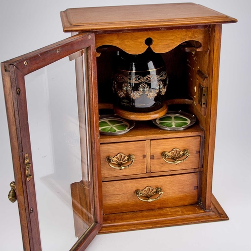 233 - AN EDWARDIAN OAK SMOKERS CABINET the interior with a tobacco jar and pair of ashtrays. 39.5cm high... 