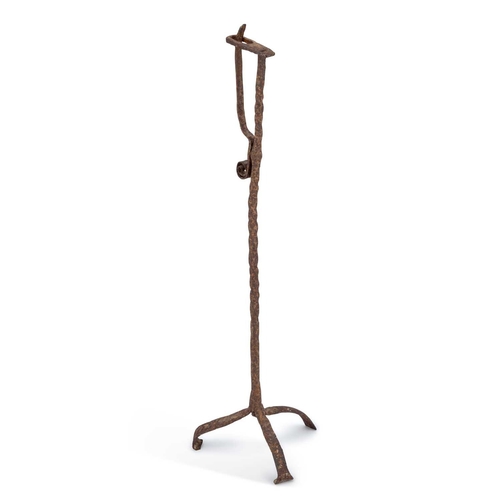 306 - A 19TH CENTURY WROUGHT IRON RUSH-NIP HOLDER raised on three feet. 68.8cm high