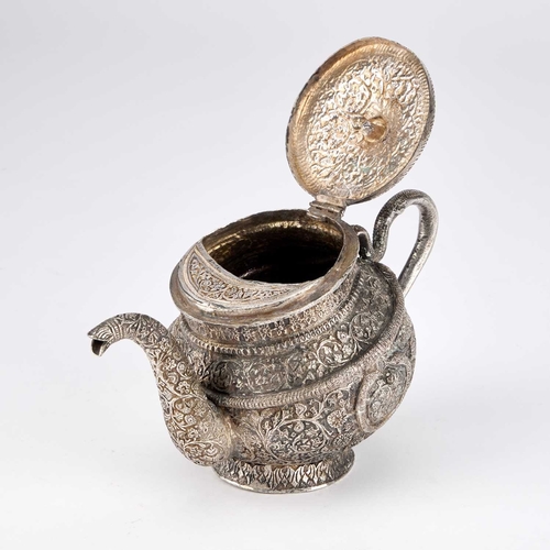 334 - AN INDAN KASHMIRI SILVER TEAPOT of tipped kang form, chased Kutch pattern with segments and floral f... 