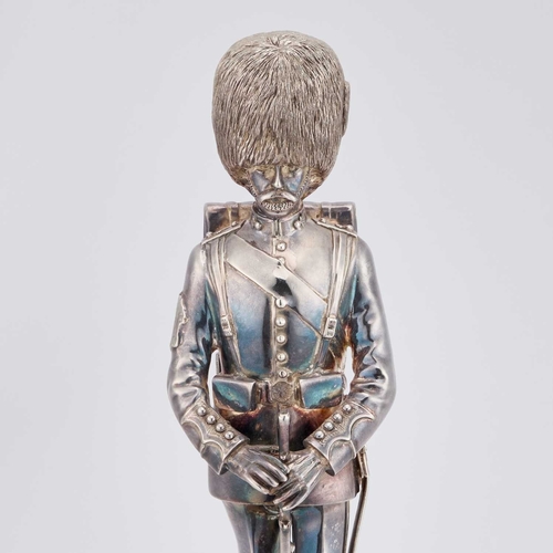 465 - AN UNMARKED FIGURE OF A GRENADIER GUARD modelled standing, raised on an ebonised plinth. 35.5cm high... 