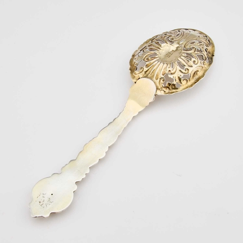 506 - A VICTORIAN SILVER-GILT SERVING SPOON by Charles Edwards, London 1900, the pierced bowl chased with ... 