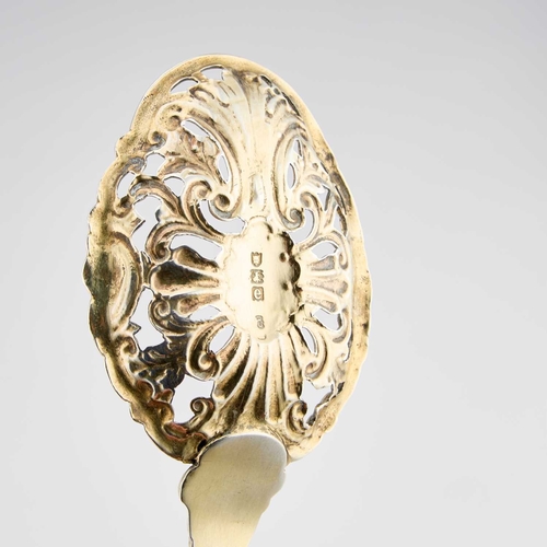 506 - A VICTORIAN SILVER-GILT SERVING SPOON by Charles Edwards, London 1900, the pierced bowl chased with ... 