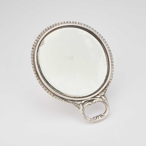 540 - A VICTORIAN SILVER HAND-MIRROR by William Comyns & Sons, London 1896, circular form, chased with... 