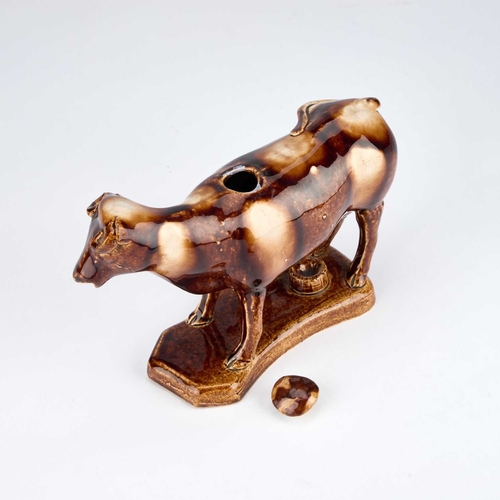 820 - A 19TH CENTURY STAFFORDSHIRE TREACLE-GLAZED POTTERY COW CREAMER AND MILKMAID GROUP modelled as a sta... 