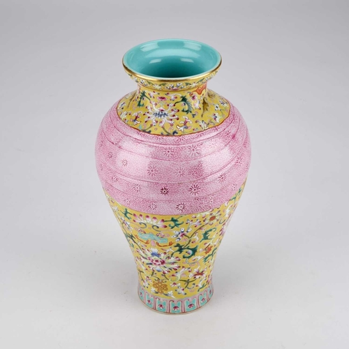 874 - A CHINESE FAMILLE ROSE YELLOW-GROUND VASE of baluster form, moulded with a tied pink swag, bears an ... 