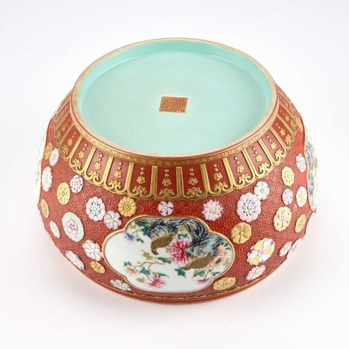 892 - A CHINESE FAMILLE ROSE ENAMELLED CORAL-RED GROUND JARDINIÃRE the rounded sides reserved with four l... 