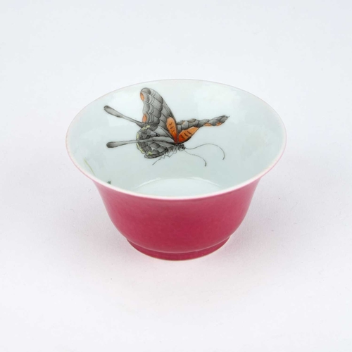 941 - A CHINESE RUBY-BACK TEA BOWL with a flared rim, the interior painted with butterflies and a floral s... 