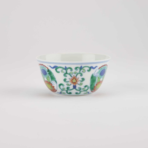 141 - A CHINESE DOUCAI CUP decorated with three floral medallions, bears an underglaze blue six-character ... 