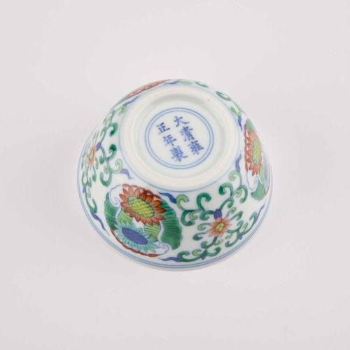 141 - A CHINESE DOUCAI CUP decorated with three floral medallions, bears an underglaze blue six-character ... 