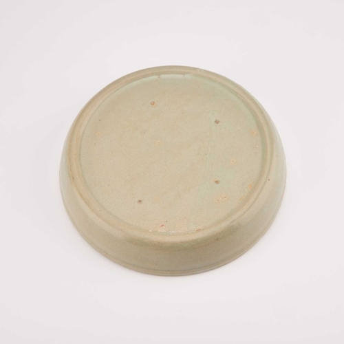 149 - A CHINESE CELADON BRUSH WASHER circular, moulded in relief with a Kylin. 17.5cm diameter