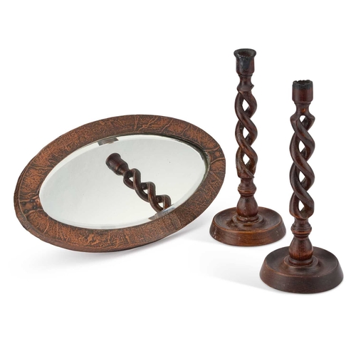 29 - A SMALL ARTS AND CRAFTS COPPER-MOUNTED OVAL MIRROR AND A PAIR OF OAK OPENTWIST CANDLESTICKS (3) Mirr... 