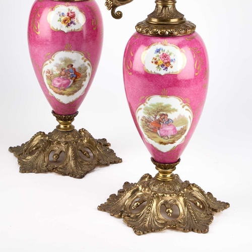 114 - A LARGE PAIR OF GILT-METAL MOUNTED PORCELAIN LAMP BASES each in the form of a ewer, the scroll-form ... 