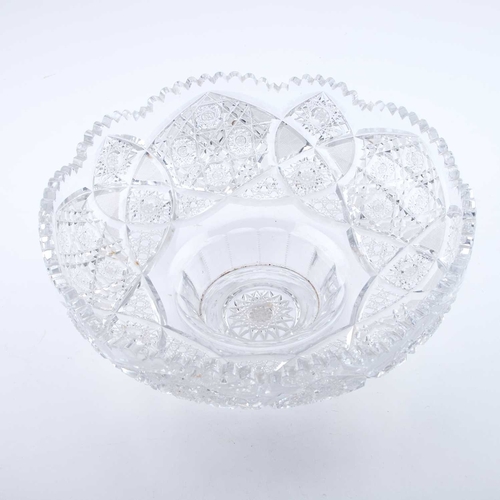 16 - A VERY LARGE CUT-GLASS CENTREPIECE the circular bowl and base with a serrated rim, boldly decorated ... 