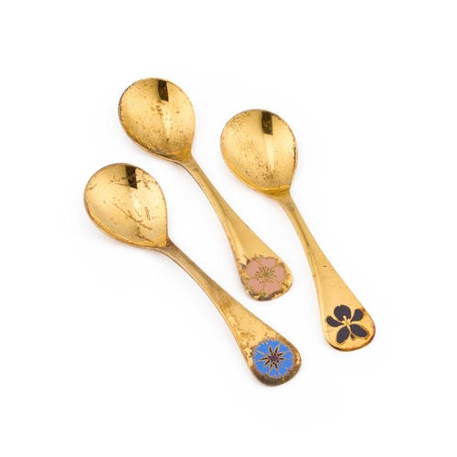 177 - GEORG JENSEN: THREE DANISH STERLING SILVER-GILT AND ENAMEL SPOONS by Georg Jensen, each handle dated... 