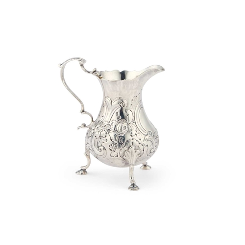 305 - AN EARLY GEORGE III SILVER CREAM JUG maker's mark indistinct, London 1761, chased with scrolls and f... 