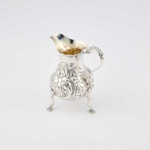 305 - AN EARLY GEORGE III SILVER CREAM JUG maker's mark indistinct, London 1761, chased with scrolls and f... 