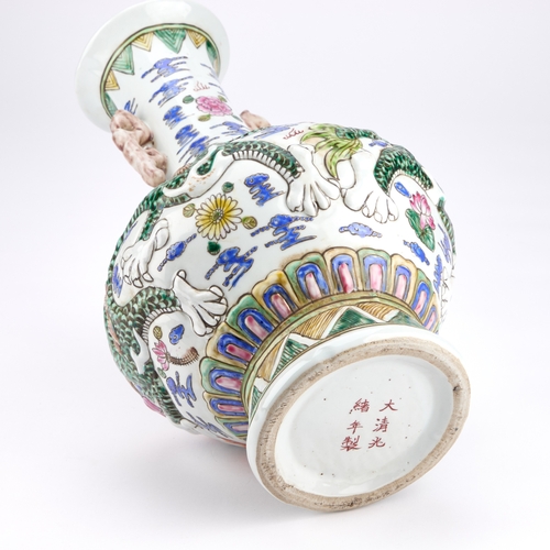 115 - A LARGE CHINESE FAMILLE ROSE MOULDED PORCELAIN VASE with a squat circular body and high flared neck,... 