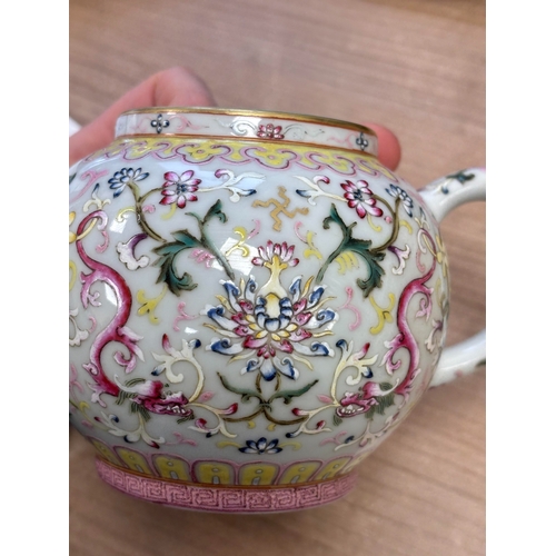 119 - A CHINESE FAMILLE ROSE TEAPOT enamel painted with lotus flowers and scrolling tendrils, bears an und... 