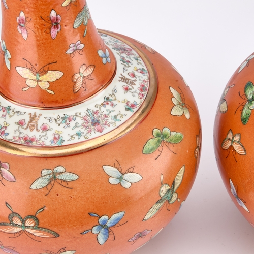 131 - A PAIR OF CHINESE FAMILLE ROSE 'BUTTERFLY' VASES each decorated on a vibrant coral ground, enamelled... 