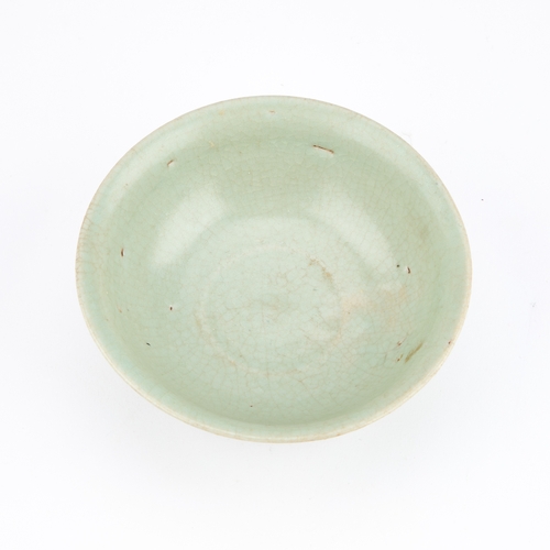 153 - A CHINESE CELADON BOWL with lightly fluted decoration, within a wooden case. 13.5cm diameter