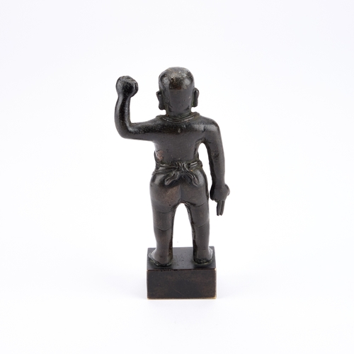 173 - A CHINESE BRONZE FIGURE OF BUDDHA modelled standing with one arm raised clenched in a fist, the othe... 