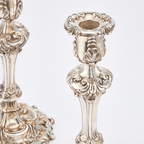 256 - A PAIR OF 19TH CENTURY SILVER-PLATED CANDLESTICKS boldly cast with scrolls and foliage. (2) 23cm hig... 