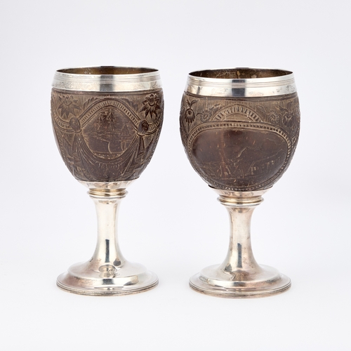 505 - A PAIR OF GEORGE III SILVER-MOUNTED COCONUT CUPS maker I.T?, London 1804, each intricately carved wi... 