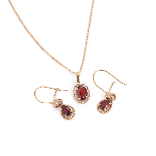 615 - A GARNET PENDANT NECKLACE AND EARRING SET the pendant set with an oval-cut garnet within a rope fram... 