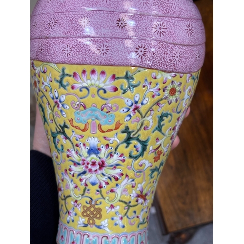 94 - A CHINESE FAMILLE ROSE YELLOW-GROUND VASE of baluster form, moulded with a tied pink swag, bears an ... 