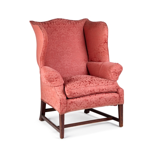 960 - A GEORGE III MAHOGANY AND UPHOLSTERED WING-BACK ARMCHAIR raised on square-section tapering legs join... 