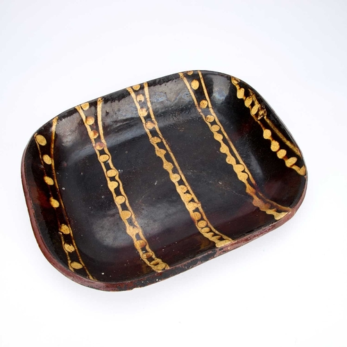 101 - A BUCKLEY POTTERY SLIPWARE BAKING DISH EARLY 19TH CENTURY of rounded rectangular form, decorated wit... 