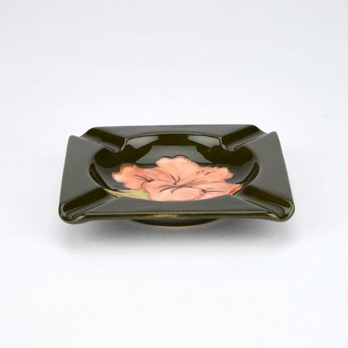 123 - A MOORCROFT POTTERY ASHTRAY square, tubelined and hand-painted with Hibiscus on a green ground, impr... 