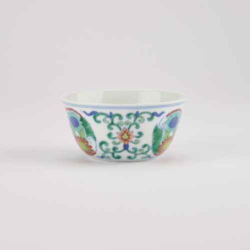 202 - A CHINESE DOUCAI CUP decorated with three floral medallions, bears an underglaze blue six-character ... 