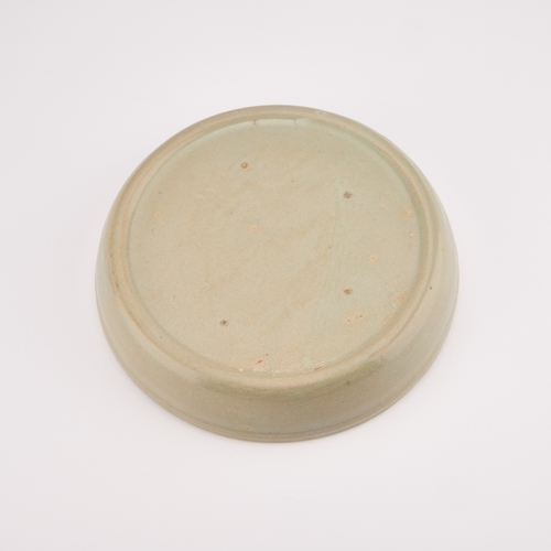 204 - A CHINESE CELADON BRUSH WASHER circular, moulded in relief with a Kylin. 17.5cm diameter