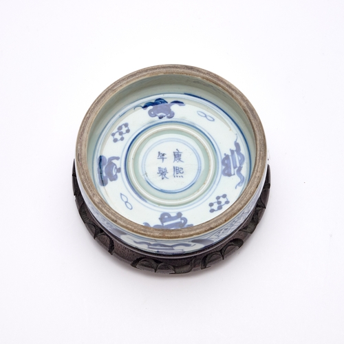 215 - A CHINESE BLUE AND WHITE PORCELAIN INK STONE circular, on a wooden stand. Ink stone 13.5cm diameter... 