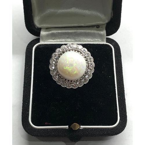 184 - 18ct white gold diamond and opal ring the central opal measures approx 14mm dia with diamonds around... 