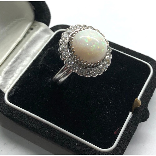 184 - 18ct white gold diamond and opal ring the central opal measures approx 14mm dia with diamonds around... 