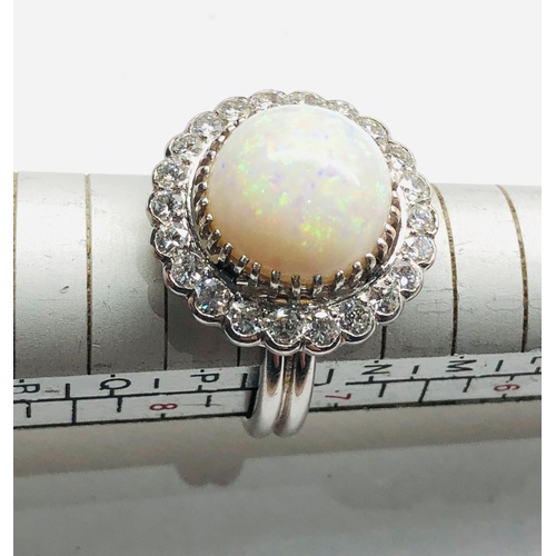 184 - 18ct white gold diamond and opal ring the central opal measures approx 14mm dia with diamonds around... 