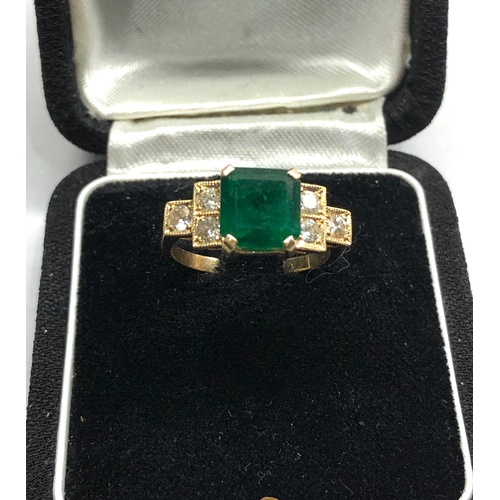 187 - 18ct diamond and emerald ring central emerald measures approx 8mm by 8mm with diamonds either side