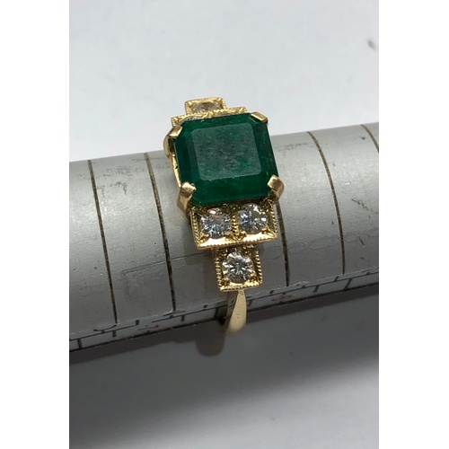 187 - 18ct diamond and emerald ring central emerald measures approx 8mm by 8mm with diamonds either side