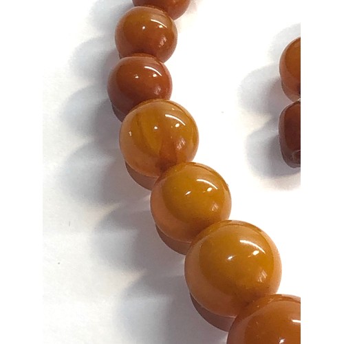 174 - Egg yolk butterscotch amber type bead necklace largest bead measures approx 21mm dia weight 55g