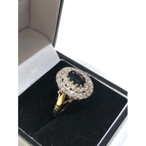 64 - 18ct gold diamond and sapphire ring weight 6.7g central stone measures approx 7mm by 5mm set with 2 ... 